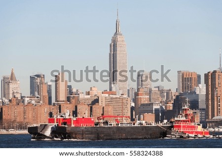 Barge floating by New York City skyline