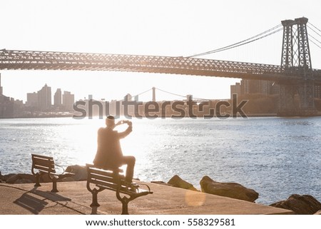 Man taking pictures of urban bridge