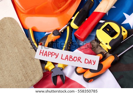 Labour Day card on flag. Tool kit and greeting paper. Labor moves the progress.