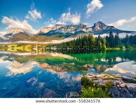 Reflexion of blue sky in the pure water of Hintersee lake. Colorful summer morning in the Austrian Alps, Salzburg-Umgebung district, Austria, Europe. Artistic style post processed photo.