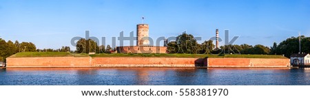 Medieval Wisloujscie Fortress with old lighthouse tower in port of Gdansk, Poland. A unique monument of the fortification works. Wide panorama in sunset light.