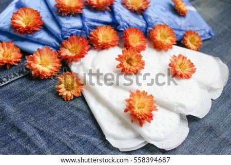 feminine pads with flowers on denim background