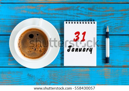 January 31st. Day 31 of month, calendar on blue wooden office workplace background. Winter at work concept