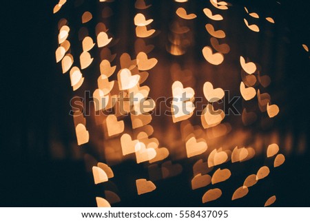 Hearts bokeh on street of evening city in dark texture for use in graphic design. Valentines style defocused lights background. St. Valentine's Day. Royalty-Free Stock Photo #558437095