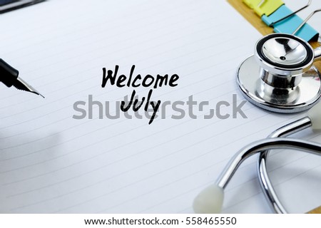 Business Concept - View of pen, stethoscope and clipper written with WELCOME JULY  on blank paper background.