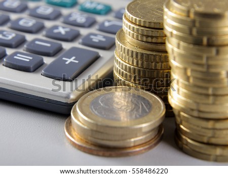 Stack of coins and calculator