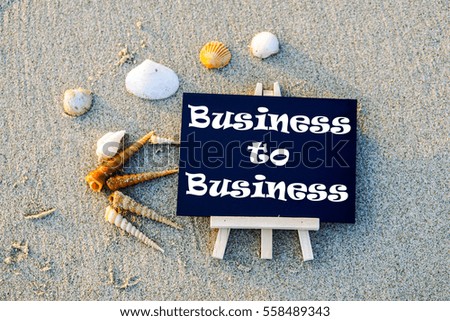 Blackboard with text "BUSINESS TO BUSINESS" on beach.