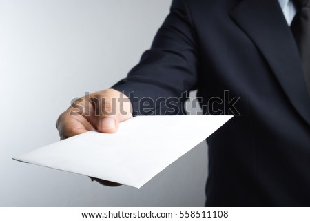 Business man hand holding envelope on white background Royalty-Free Stock Photo #558511108