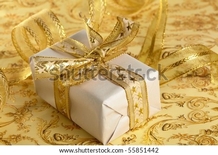 Beautiful gift box on the gold background