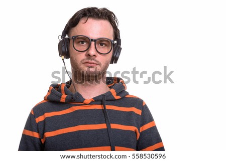 Studio shot of young man listening to music isolated against white background