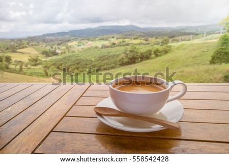 White coffee cup on wooden tables and outdoor mountain background - Processing color effect style pictures