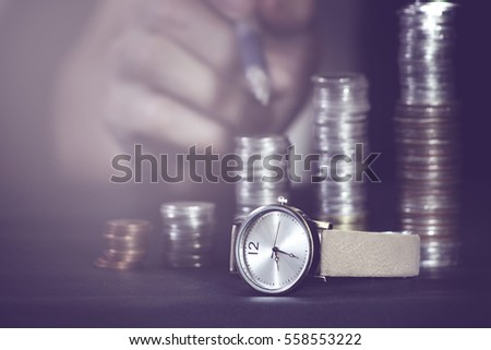 Close up of stacking coins with watch,focus of watch