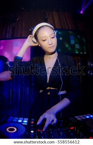 Blurred Lady Dj in club party,slow sync flash technique is feeling movement
