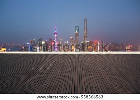 Aerial photography bird view at Empty wood floor with city landmark buildings background at Shanghai bund Skyline of night scene