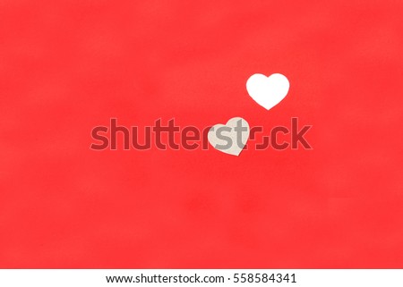 One heart cut from the center of the red paper.