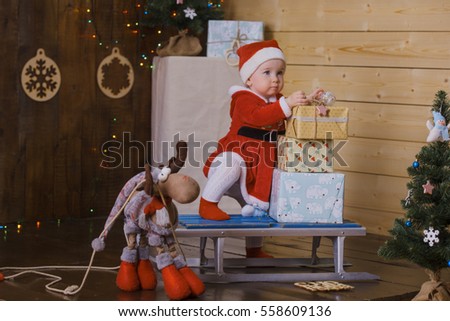  little girl in Santa Claus sledge with gifts