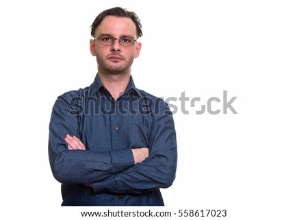 Studio shot of formal young man wearing eyeglasses with arms crossed isolated against white background