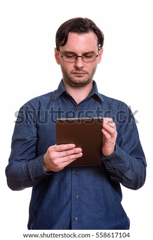 Studio shot of formal young man using digital tablet isolated against white background