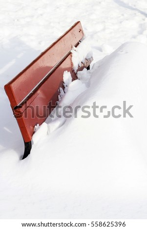 Bench in park covered with snow after a big storm