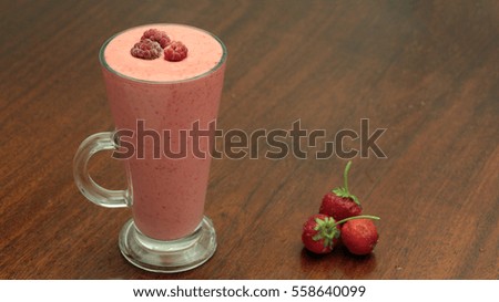 Raspberry and Strawberry Smoothie in a Glass on Wooden Table