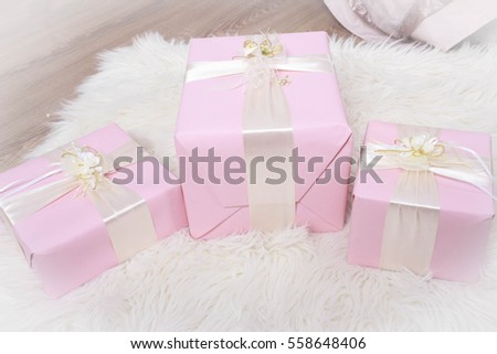 Three pink gifts with satin bows and bouquet of chrysanthemums isolated