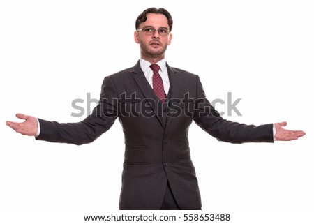 Studio shot of young businessman showing something with both hands raised isolated against white background