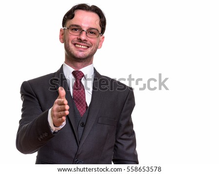 Studio shot of young happy businessman smiling while giving handshake isolated against white background