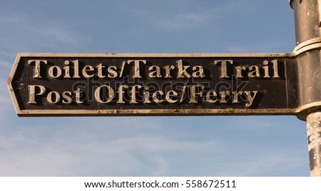 Sign Post for "Toilets/Tarka Trail, Post Office/Ferry" in the Holiday Resort of Instow on the North Coast of Devon, England, UK