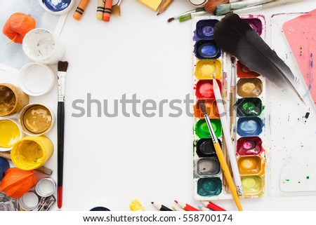 Gouache and watercolor dye palette on white table. Artist workplace with colorful drawing tools, free space. Art, workshop, painting, inspiration, craft, creativity concept