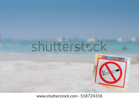 close up of no smoking sign over tropical sand beach