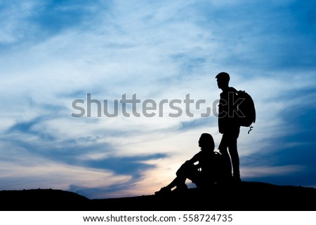 Silhouette Tourists enjoying on the mountain over sunset background.