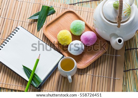 Mo chi dessert,stuffed eggs on bamboo with tea set and  blank copy space notebook