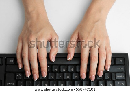 Women's hands on the black keyboard.   