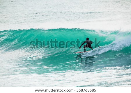 Surfing in turquoise barrel in ocean