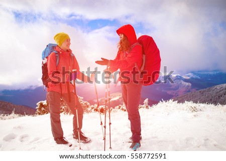 Two friends talk on the background of snow-capped mountain and beautiful sky with cloud.