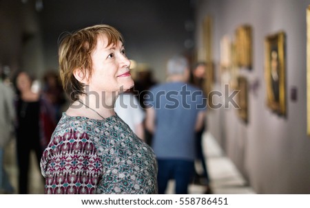 Closeup on attentive pleasant  senior woman visiting museum and enjoying arts