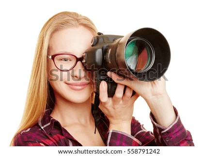 Young woman with glasses as photographer taking pictures with digital camera