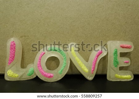 "LOVE" letter by plastic is in front of brown paper box and copy space on top of picture in love concept for valentine day