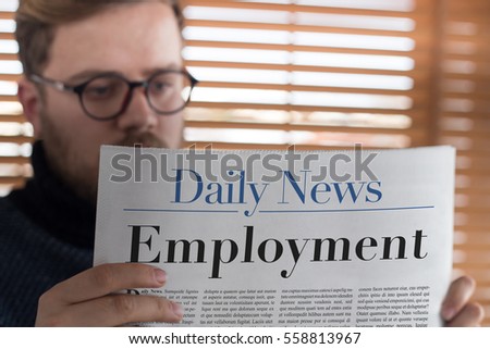 Man reading Employment headlined newspaper