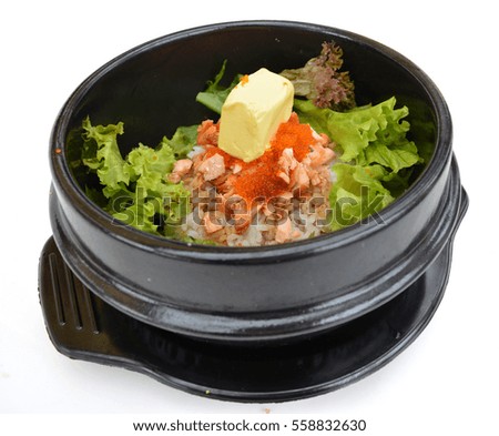 Salmon Bibimbap, rice with salmon, cod roe and butter in black pot, isolated on white background