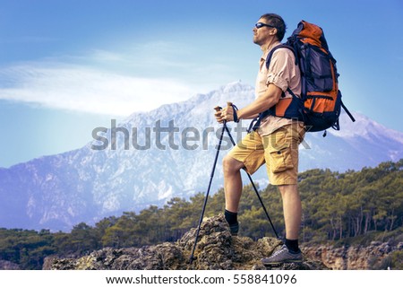 Summer hiking in the mountains with a backpack . Royalty-Free Stock Photo #558841096