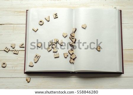 The word love a lot of hearts on a background of book on a wooden table. Back to school copy space. Education background.