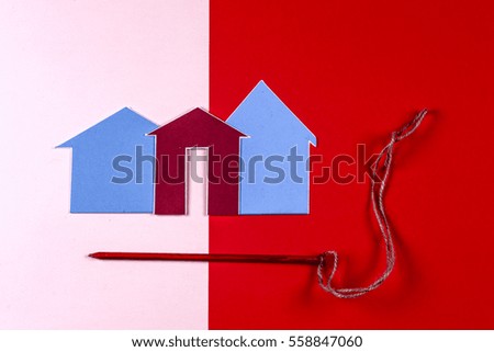 House and house and red carnations on bright colorful background. Home construction concept . Copy space for text.