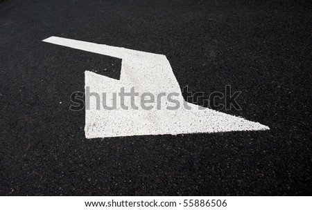 black asphalt road with arrow signals on it.