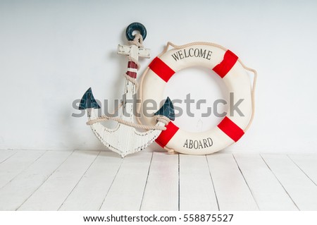 Anchor and life buoy on a white wooden floor