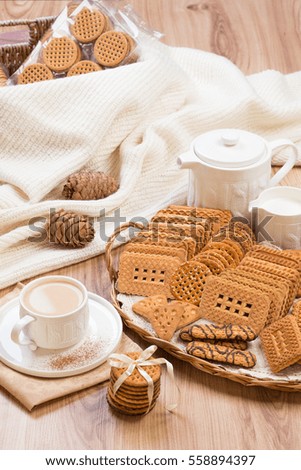 Cookies and tea with milk are on the table