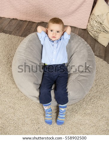 toddler boy lying with his hands behind his head