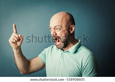 Frustrated desperate bearded middle-aged  man screaming on blue background