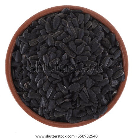 Roasted sunflower seeds in a brown bowl on a white background