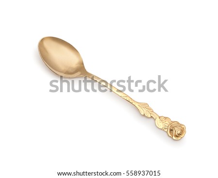 Vintage golden teaspoon with rich decorated handle in shape of rose and leaves floral ornament, isolated on a white background. Close up. Royalty-Free Stock Photo #558937015